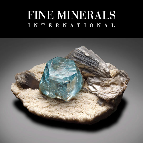 Fine Minerals International - Blue ‘Pinacoid’ Topaz with Muscovite and Smoky Quartz on Albite